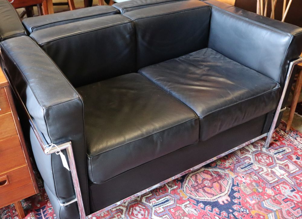 A pair of Corbusier style black leather and chrome two seater sofas, length 130cm, depth 66cm, height 68cm